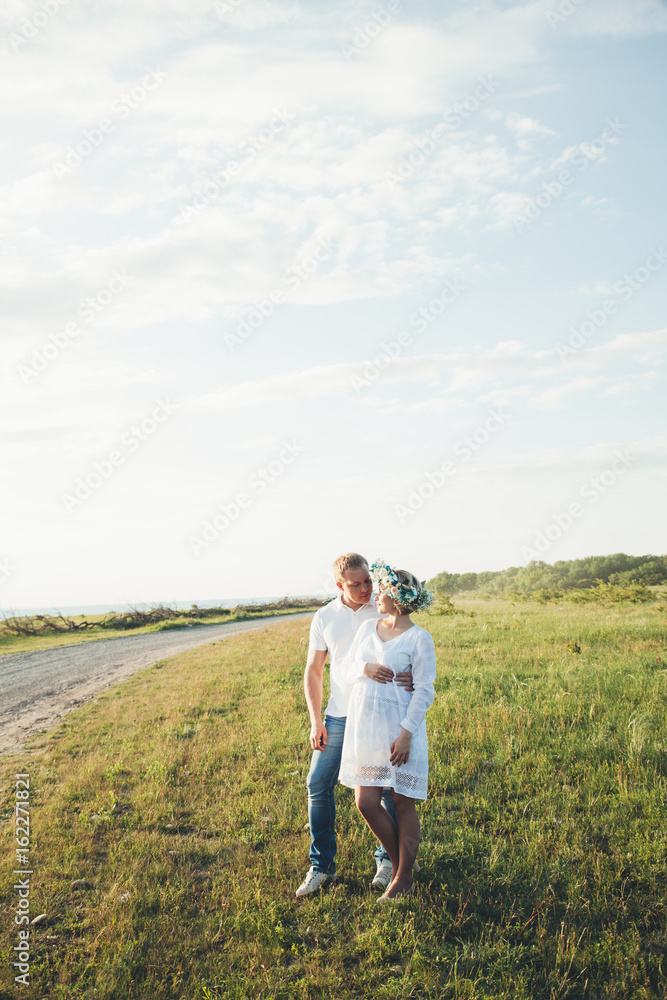 beautiful pregnant girl and her husband in the nature