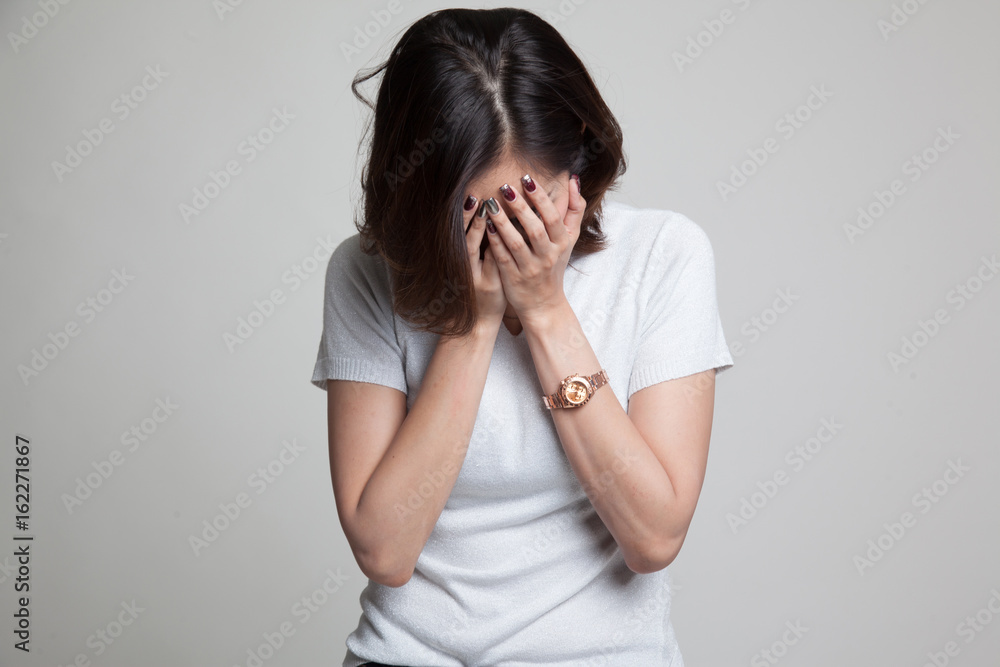 Sad young Asian woman cry with palm to face. Sad young Asian woman cry with palm to face.