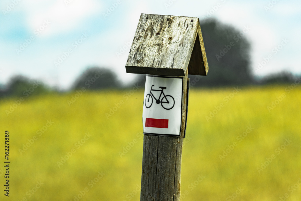 Bicycle sign on field  with blue sky.