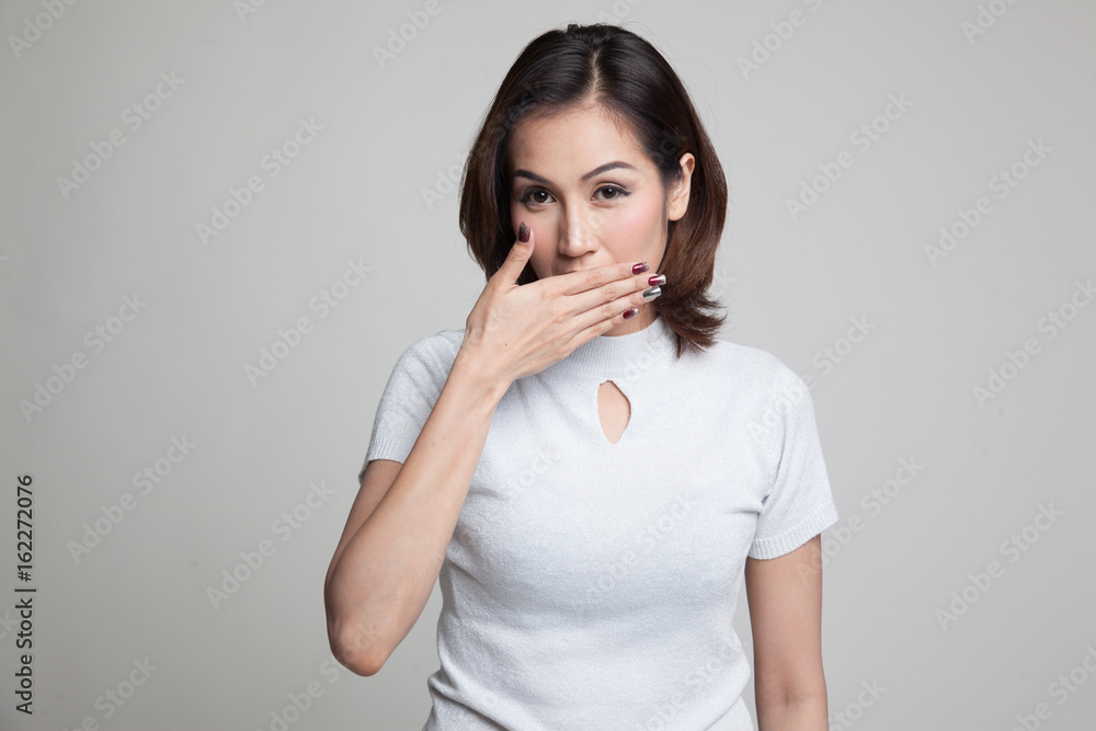 Young Asian woman close her mouth with hand. Young Asian woman close her mouth with hand.