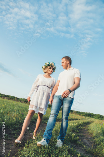 beautiful pregnant girl and her husband in the nature