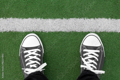Sneakers at artificial green grass playground