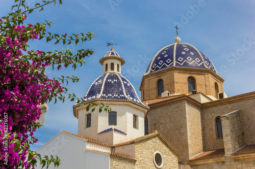 Pink flowers in front of the blue domes of the Altea church photo