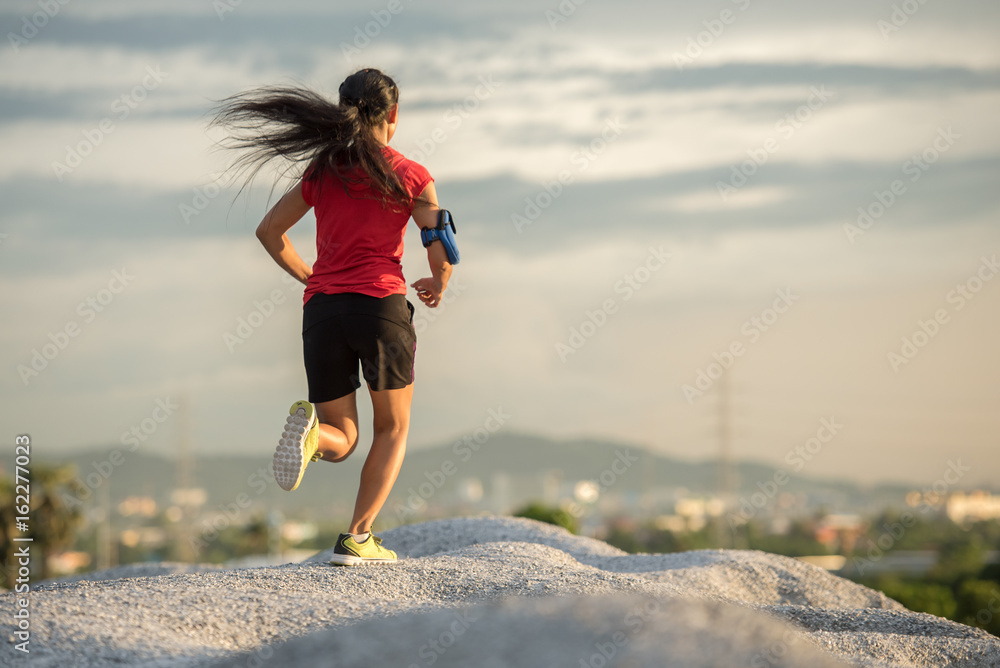 Woman running. Female runner jogging, training for marathon. Fit girl fitness athlete model exercising outdoor