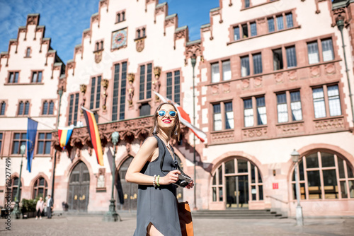 Young female tourist with photo camera enjoying visiting the old city center of Frankfurt city photo
