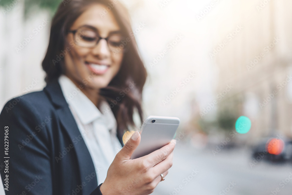 Happy smiling woman talking via smartphone with friend while walking during lunch time Happy smiling woman talking via smartphone with friend while walking during lunch time