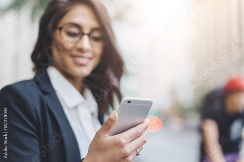 Close up of female employer hands using modern smartphone outdoors, Business woman reading the message via cell phone while going to office