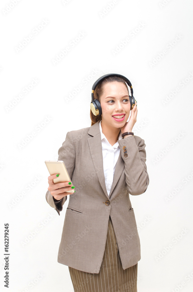 beautiful asian young business woman smiling in suit standing relaxing and using smartphone listening to music in headphone isolated on white background beautiful asian young business woman smiling in suit standing relaxing and using smartphone listening to music in headphone isolated on white background