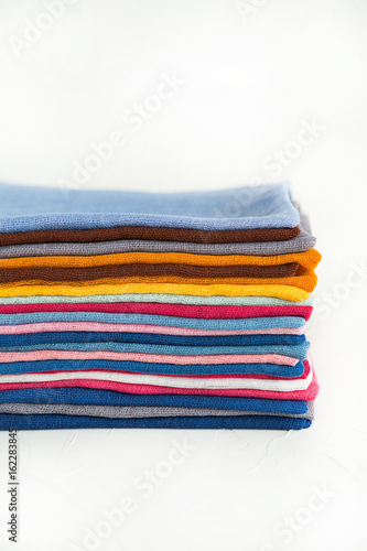 A pile of cotton fabric in a store or a wardrobe. Colorful textile.