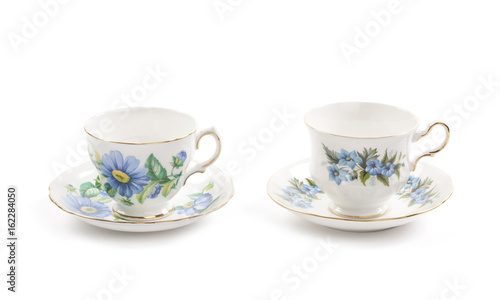 Two beautiful vintage tea cups with saucers isolated on a white background.