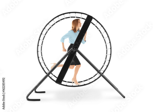 Young woman running in wheel on white background. Business rat race concept © Africa Studio