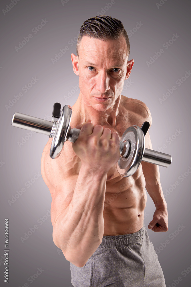fit muscular man posing isolated on a grey background fit muscular man posing isolated on a grey background