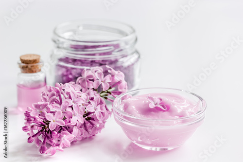 organic salt  cream  extract in lilac cosmetic set with flowers on white table background