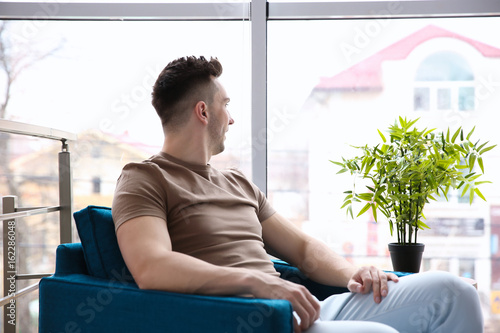 Man sitting in armchair nea...