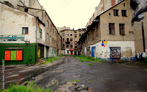 Opustoszałe Łódzkie podwórze, ze zrujnowanymi blokami i zniszczonymi witrynami
