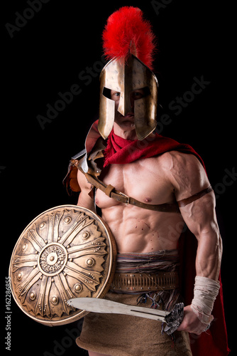 Plakat gladiator posing isolated in dark