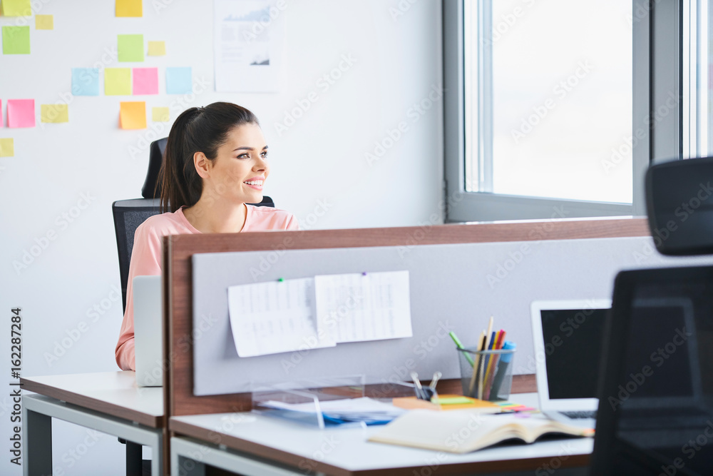 Confident young employee working at her desk Confident young employee working at her desk