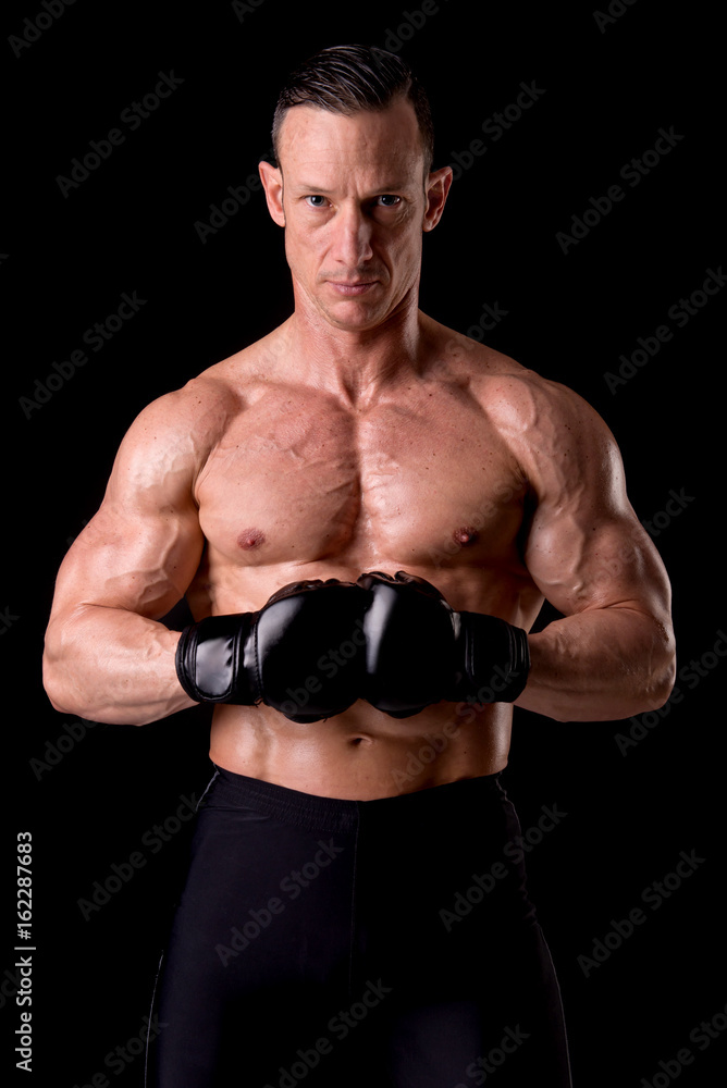 Naklejka premium fighter posing with gloves isolated on a dark background