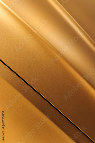 Surface of bronze sport sedan car, detail of metal hood, fender and door of vehicle bodywork 