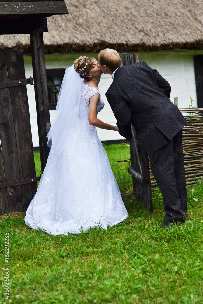 happy bride and groom kissing in the old village