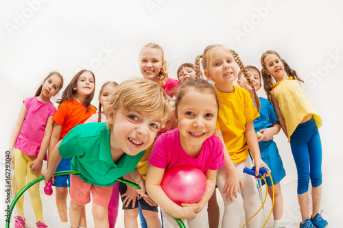 Sporty kids and gymnastics coach having fun in gym