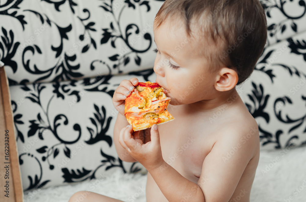 The boy eats a piece of delicious pizza The boy eats a piece of delicious pizza