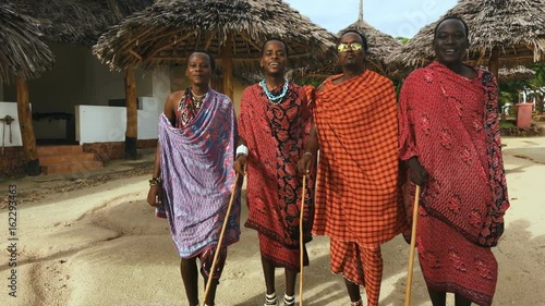 The Masai tribe dances their national African dance on the Indian Ocean beach at sunset and bids farewell to the sun. Tanzania. Zanzibar. 4K.