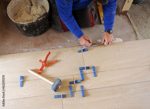 Foto Bricklayer who is writing down the measure to place the next row of porcelain st