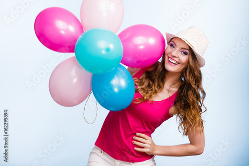 Woman playing with many colorful balloons