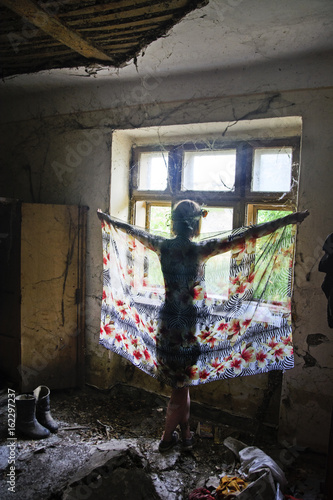 Young girl in front of an old window © banedeki1