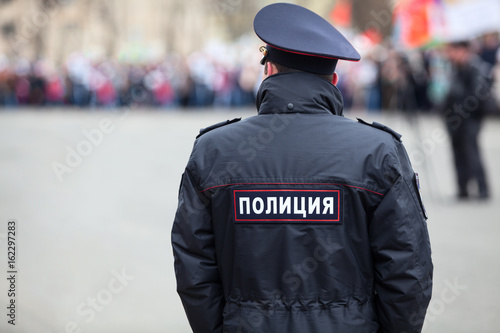 Russian policeman officer standing back to camera with inscription Police on the uniform jacket, Russia, copyspace