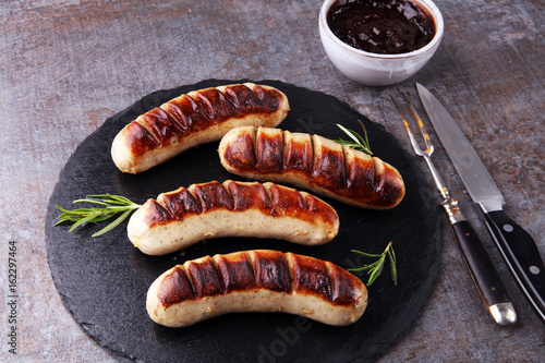 Grilled sausages with sauce ketchup on a wooden table - Home-made Pork Sausages
