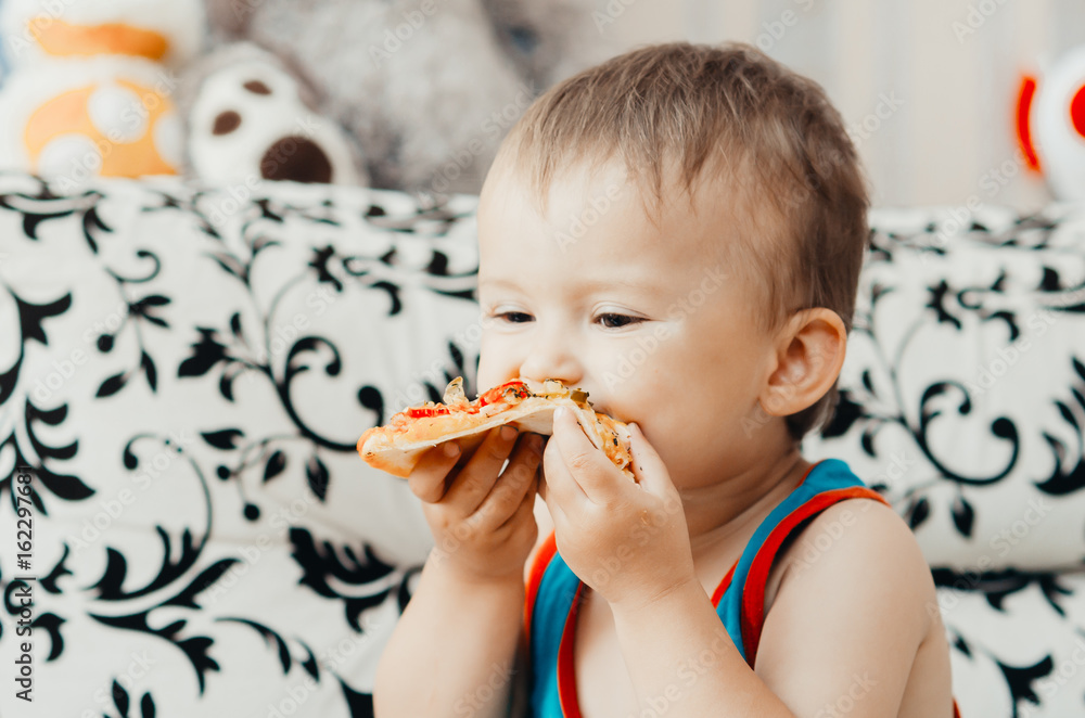 The boy eats a piece of delicious pizza The boy eats a piece of delicious pizza