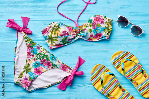 Colorful swimsuit, glasses, sandals. Bathing female suit and beach accessories.
