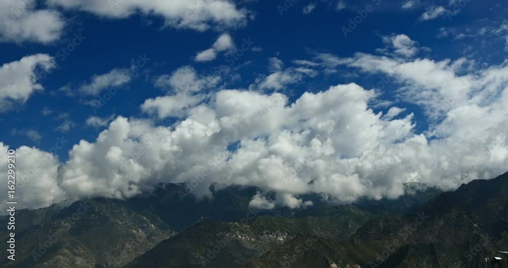 4k time lapse of white puffy clouds mass rolling over Tibet mountaintop,clouds shadow running,roof of the World. 4k time lapse of white puffy clouds mass rolling over Tibet mountaintop,clouds shadow running,roof of the World.