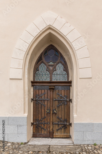 Large wooden door with wrought-iron elements. Decorative door with fittings. © murmakova