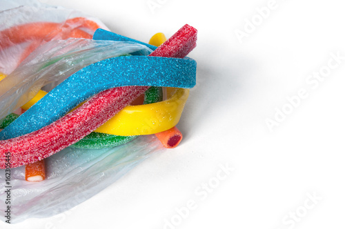 Long colorful licorice sweets  candy sticks  in package on a white background. Copy space.