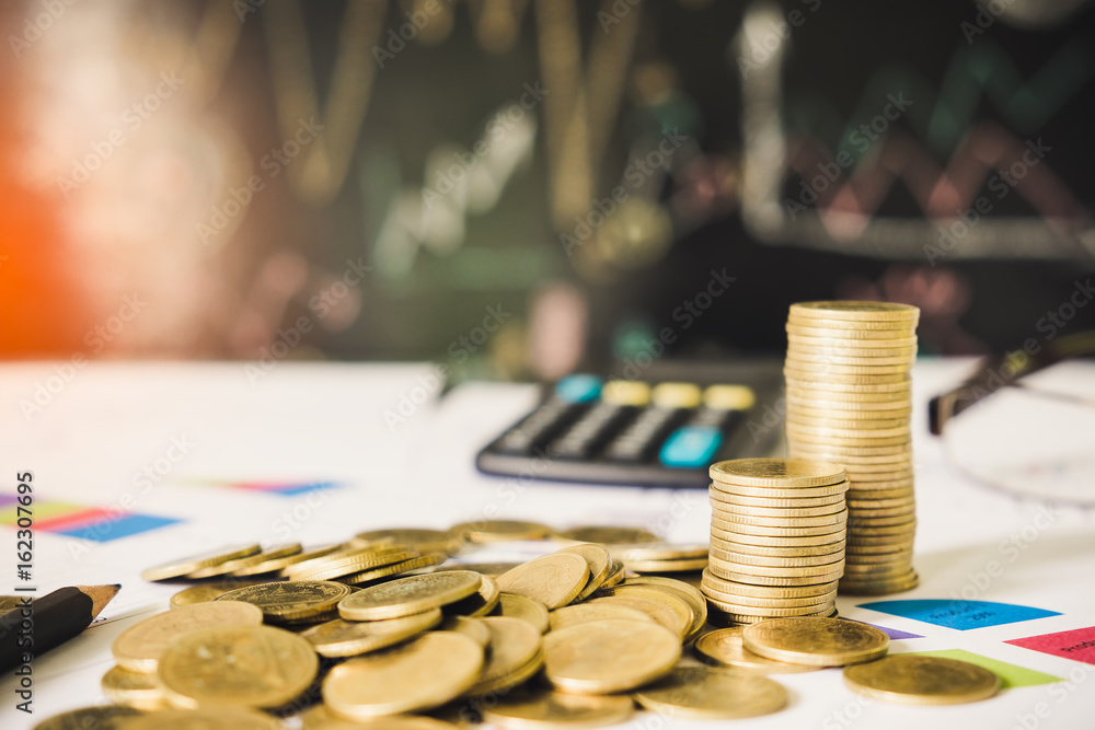 Coins stack, pencil and calculator on financial chart and graph, accounting background Coins stack, pencil and calculator on financial chart and graph, accounting background
