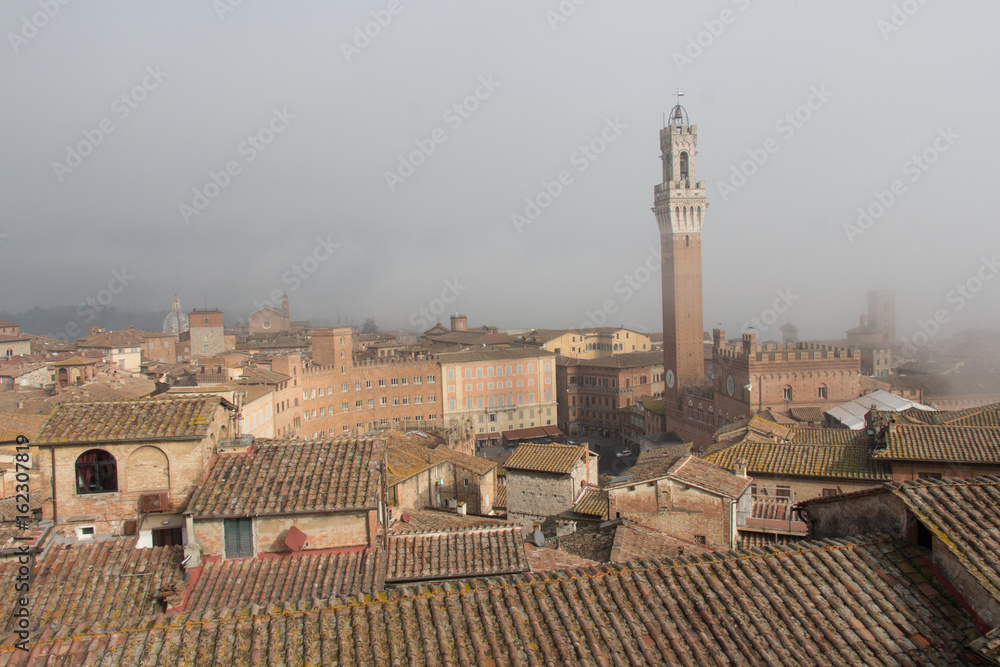 Torre del Mangia in Piazza del Campo in fog. Tuscany, Italy.