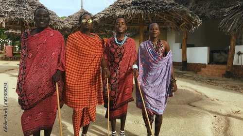 The Masai tribe dances their national African dance on the Indian Ocean beach at sunset and bids farewell to the sun. Tanzania. Zanzibar. 4K.