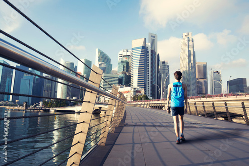 Photography Young man walking exercise along bridge near Marina bay in Singapore with Singap