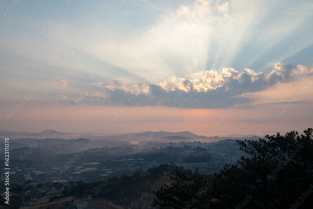 sunrise over hill with the sun radiating golden rays pierced the hills with pine trees covered with morning dew beautiful ray beam forming to welcome the new day so simple in Da lat, Vietnam