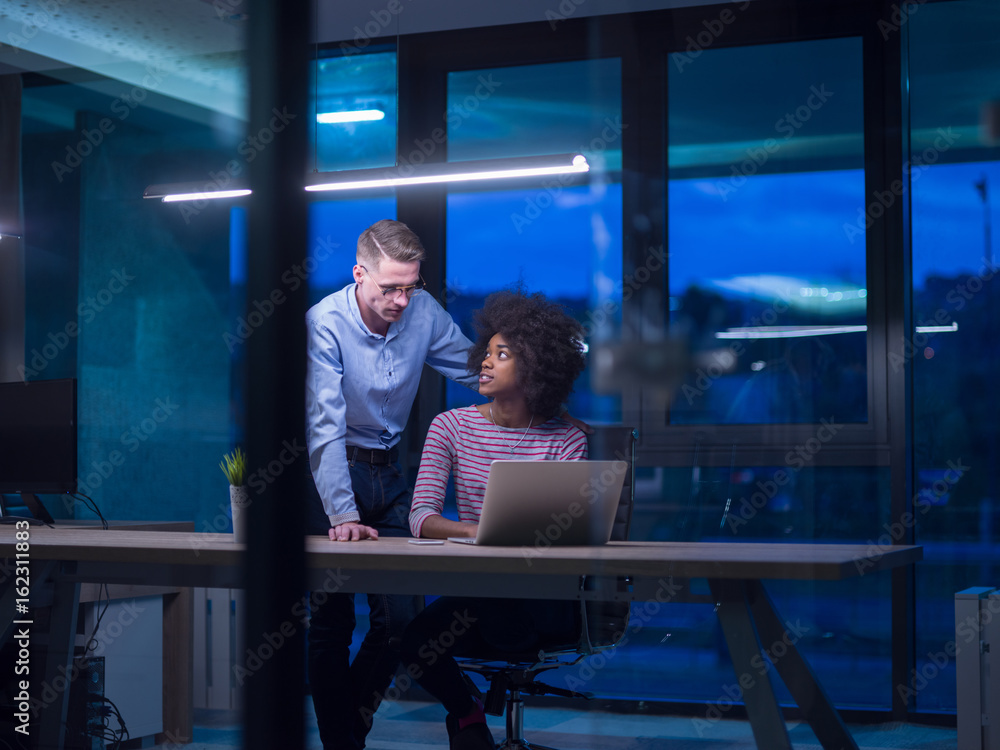 Multiethnic startup business team in night office Multiethnic startup business team in night office