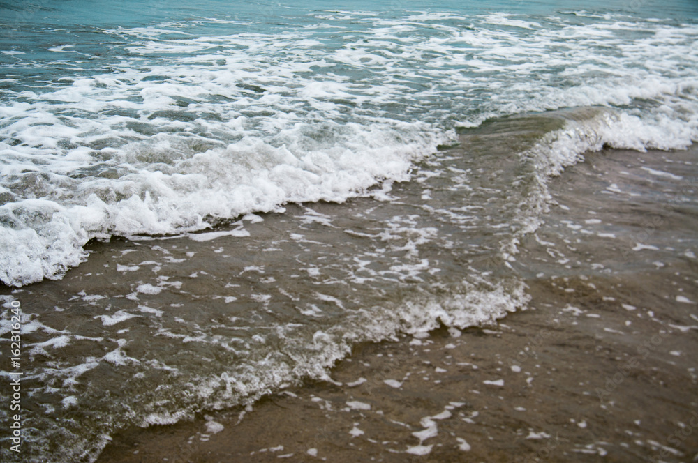 Soft wave of blue ocean on a sandy beach. With the blur. Toning. Soft wave of blue ocean on a sandy beach. With the blur. Toning.