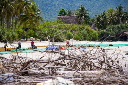 Women from a fishing village in Vietnam lay out seaweed for drying in the sun