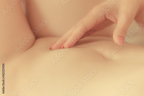 Hand on woman lower belly photo