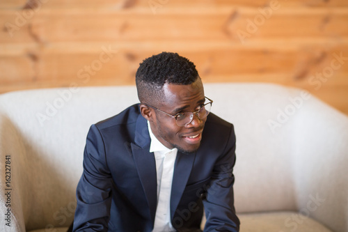 African american man small business owner smiling with mobile phone