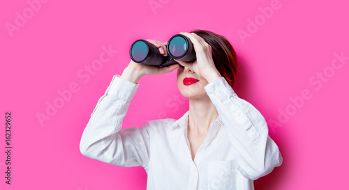 Beautiful red-haired businesswoman with binoculars photo