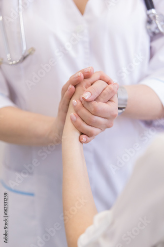Hand of doctor reassuring her patient