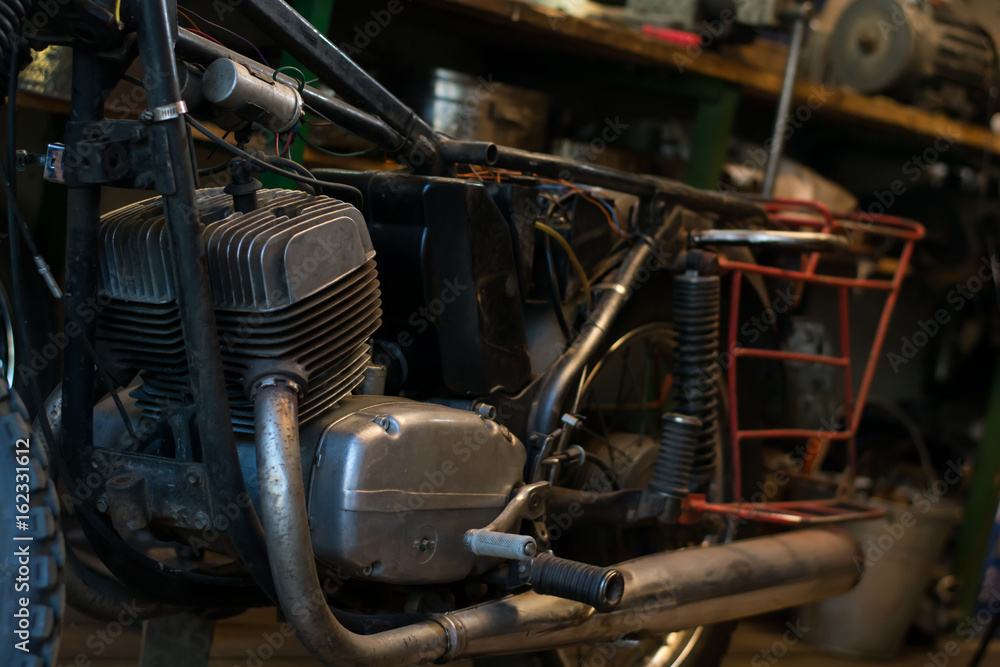 Fototapeta premium Old vintage motorcycle, which needs to be repaired, in the workshop